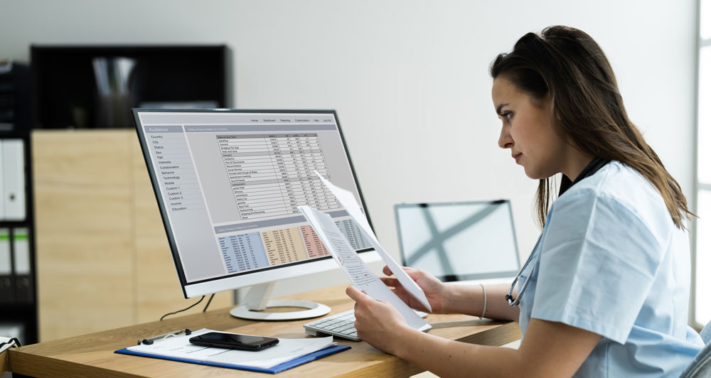 Woman looking at Medical Coding Records on Computer