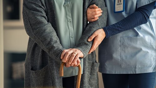 Nurse Helping Older Person with Cane